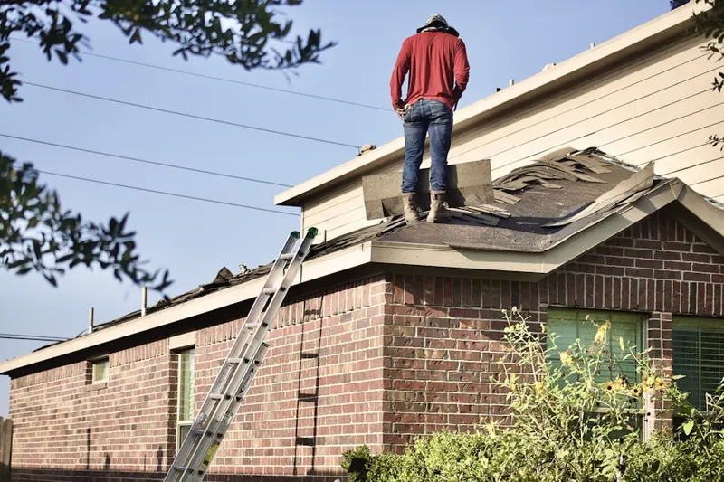 Professional roofer working on a residential roof in Friendship Heights
